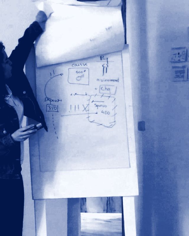 Une lycéenne présente ses idées devant un tableau